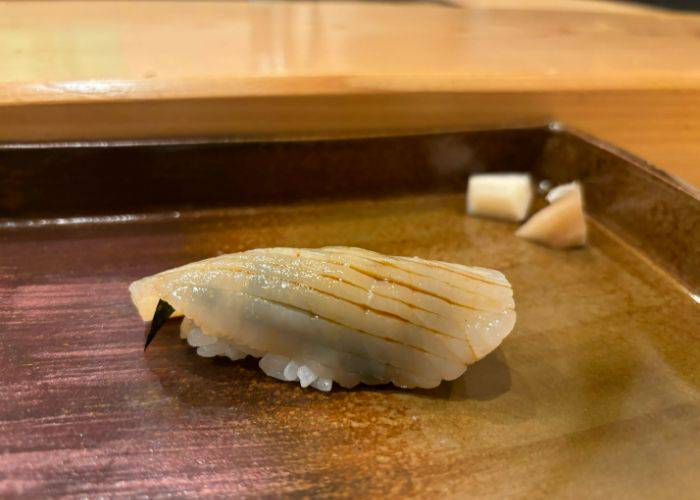 Nigiri with slices cut into the fish to soak up soy sauce.